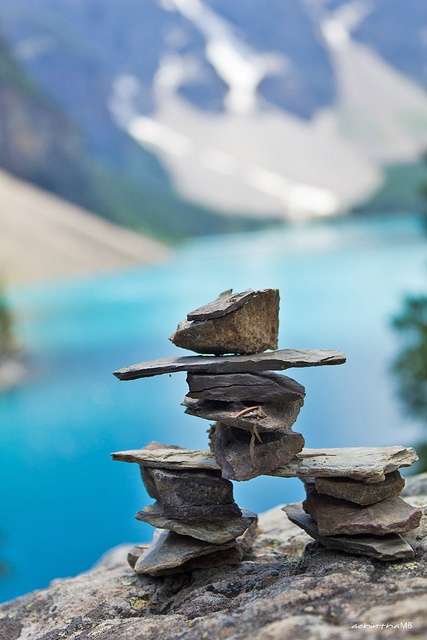 rocks stacked on top of each other with water and mountains in the backgroud