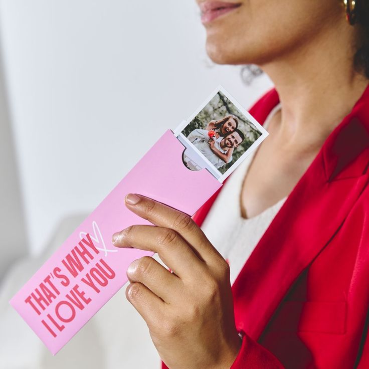 a woman holding a pink card that says, that's why i love you