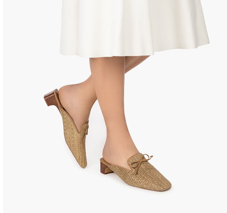 Step into casual elegance with this women's summer shoe for sale online. The Isla Mule has an upper of raffia, edged, lined and bowed in leather. The cushioned leather footbed has built-in arch support, providing stability and comfort. A one-inch stacked leather heel puts your foot in a supported position so you can be on the go throughout the day without sacrificing style. Small Leather Accessories, Summer Shoe, Women's Headwear, Navy Linen, Womens Summer Shoes, Natural Women, Costume Institute, Hats For Sale, Casual Elegance