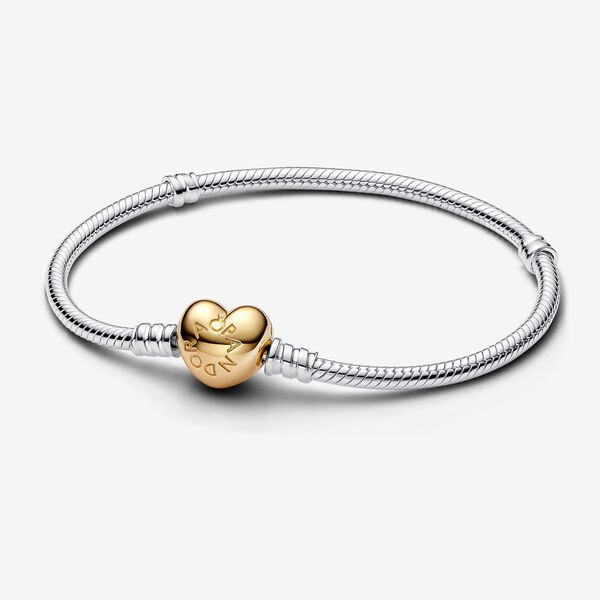 Give your charms a romantic backdrop with this Pandora Moments Heart Clasp Snake Chain Bracelet, a new rendition of our classic charm bracelet. Cast in sterling silver, the signature snake chain design is updated with a 14k gold-plated unique metal blend heart-shaped clasp. The clasp is stamped with the Pandora logo. Available in-store and online. | Pandora Moments Heart Clasp Snake Chain Bracelet in Sterling silver/14k Gold-plated unique metal blend in Various Sizes Pandora Chain Bracelet, Pandora Charms Bracelet, Pandora Logo, Dangle Bracelet, Bracelet Pandora, Gift Bracelet, Silver Plated Bracelet, Snake Chain Bracelets, Mesh Bracelet