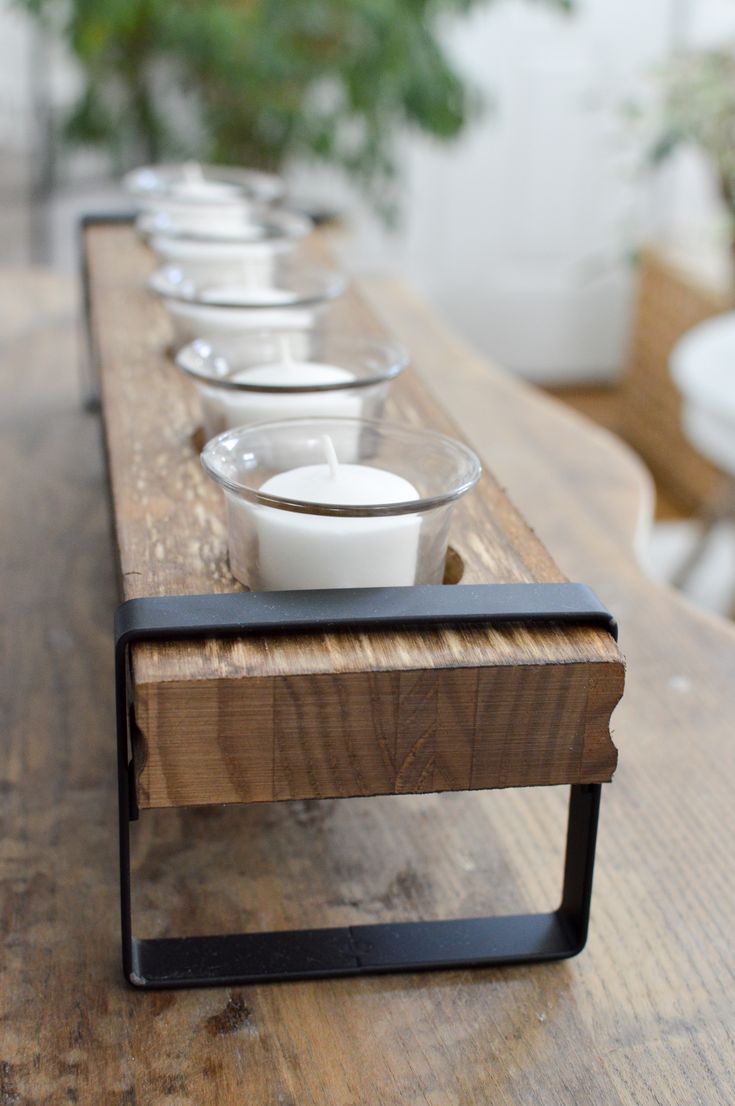 a row of glass cups sitting on top of a wooden table