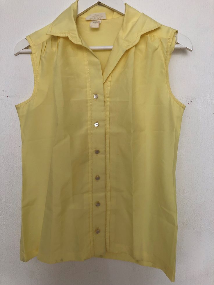 A beautiful vintage top is a wardrobe essential that stands out, yellow colour and has a delicious summer cotton top. Short sleeve and buttons in front for a subtle style. Suitable for machine wash. Summer Cotton Button-up Blouse, Cotton Sleeveless Blouse For Spring, Sleeveless Cotton Blouse For Spring, Cotton Summer Blouse With Buttons, Sleeveless Blouse With Buttons For Summer, Summer Sleeveless Blouse With Buttons, Sleeveless Blouse Tops With Buttons For Summer, Classic Sleeveless Blouse For Summer, Summer Tops With Button Closure For Daywear