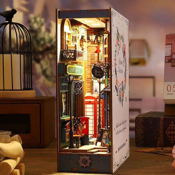 a dollhouse with furniture and accessories on a table next to a birdcage