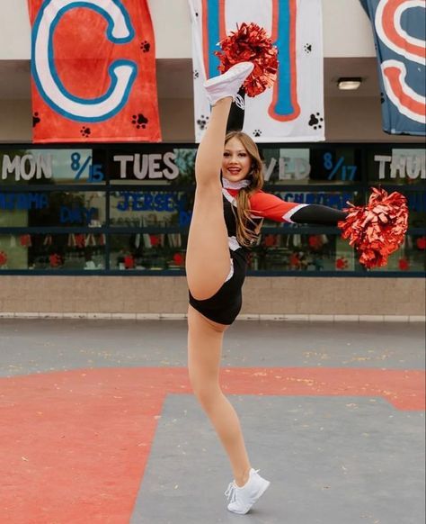 a cheerleader is performing in front of large signs and banners on the side walk