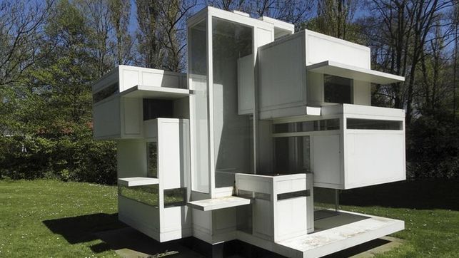 a white sculpture sitting on top of a lush green field