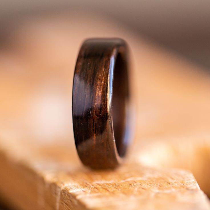 a wooden ring sitting on top of a piece of wood