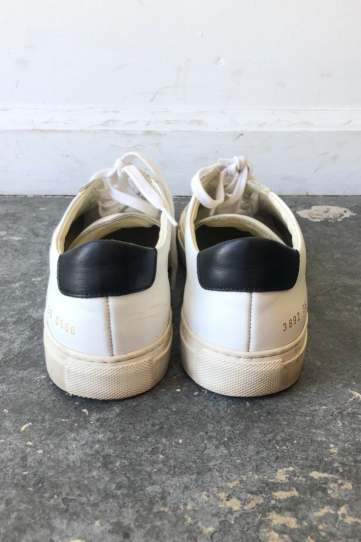 Woman by Common Projects Sneakers. White lace-up sneaker with black back panel. Size Womens 36. Made in Italy. Approx. Measurements Heel to Toe: 10" Width: 4" Classic Custom Sneakers With Rubber Heel Cap For Streetwear, Sporty White Platform Sneakers With Rubber Heel Cap, Sporty Lace-up Sneakers With Rubber Heel Cap, Urban White Sneakers With Rubber Heel Cap, Sporty White Sneakers With Rubber Heel Cap, White Urban Sneakers With Rubber Heel Cap, Sporty Custom Low-top Sneakers With Rubber Heel Cap, Modern White Custom Sneakers With Rubber Heel Cap, Urban Custom Low-top Sneakers With Rubber Heel Cap