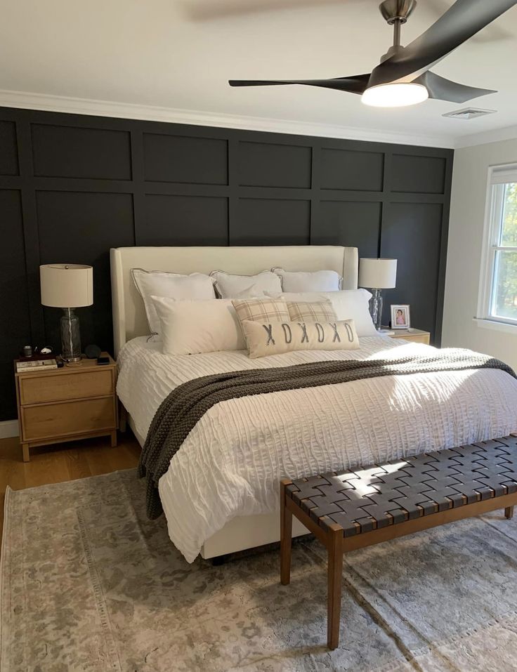 a bed room with a neatly made bed next to a window and a ceiling fan