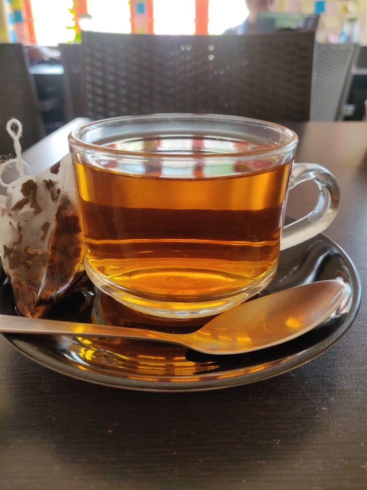 a cup of tea and spoon on a plate