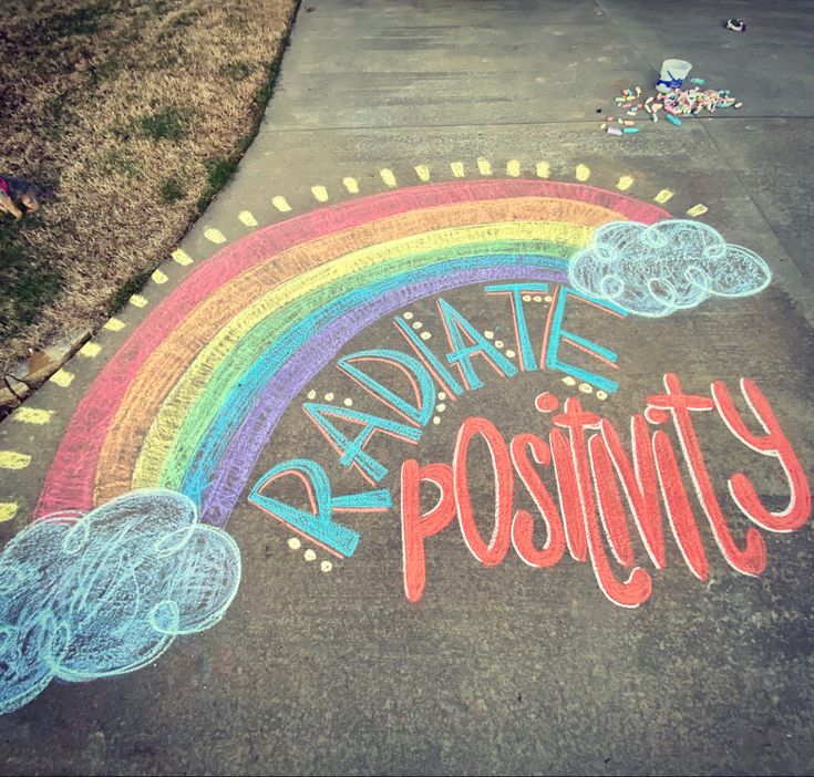 a chalk drawing that says radiate positty in front of a rainbow