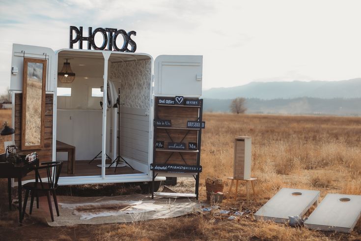 an outhouse sits in the middle of a field with its doors open and it's lights on