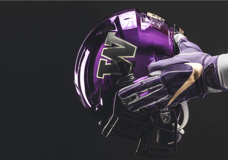 a close up of a purple lacrosse helmet and glove on a black background with the word'f'written across it