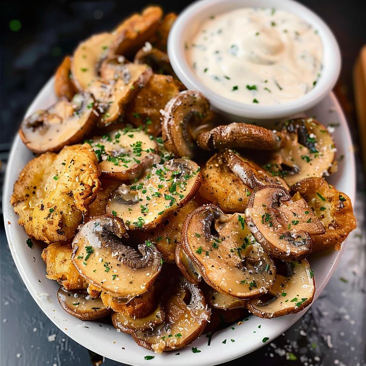 a white plate topped with fried mushrooms and dip