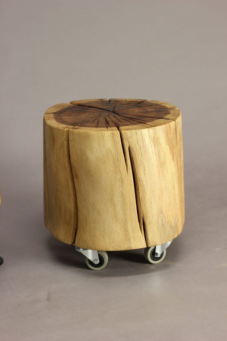 a small wooden stool with wheels on the bottom and one piece of wood that has been cut in half