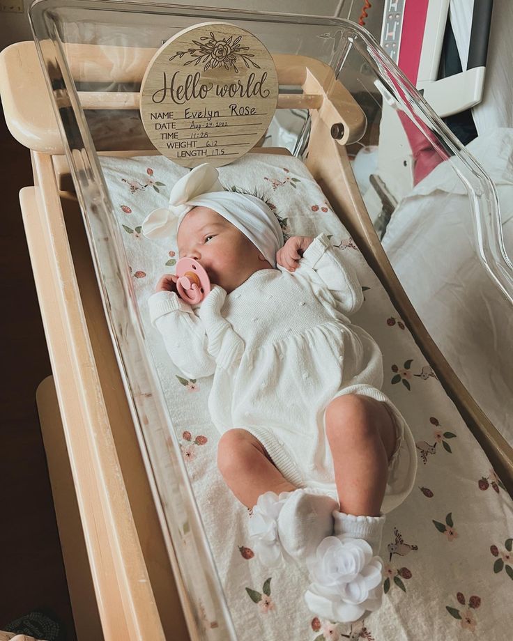 a baby laying in a crib with a hello world sign on it's head