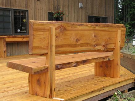 a wooden bench sitting on top of a wooden deck next to a building with windows