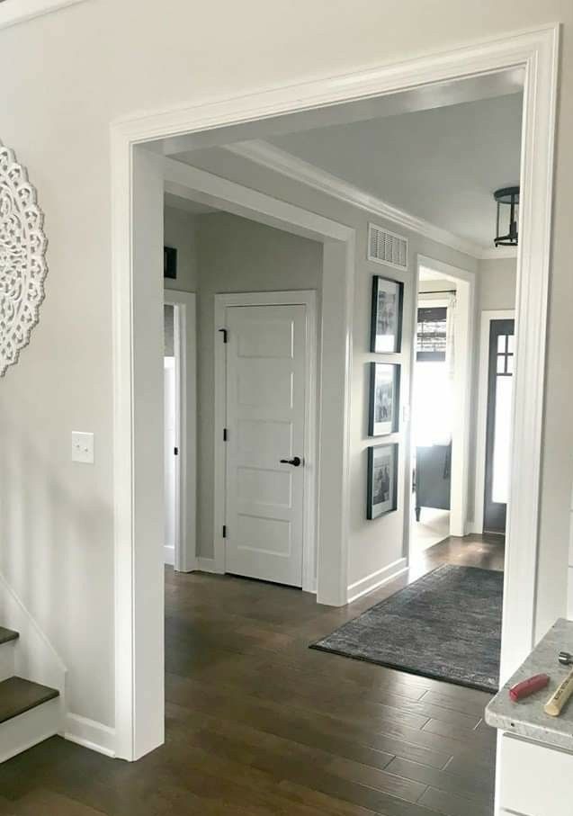 an entry way with white walls and wood floors