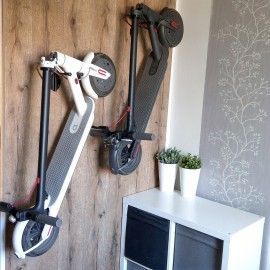 two scooters mounted to the side of a wooden wall