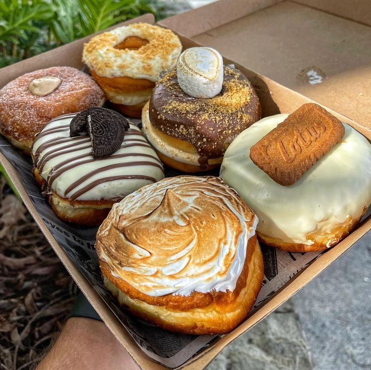 a box filled with lots of different flavored donuts