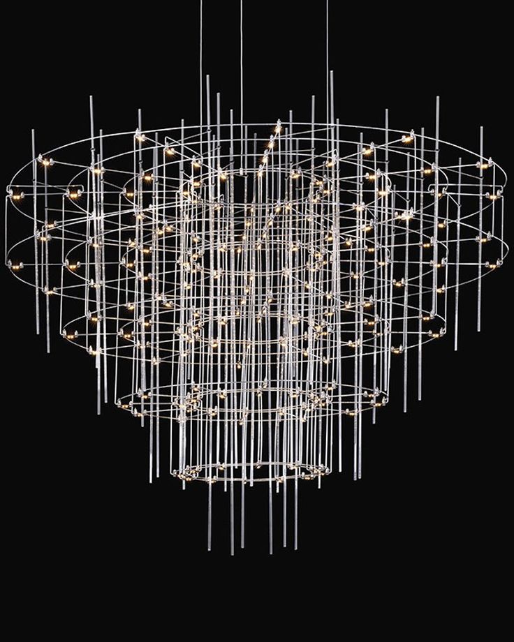 a large chandelier with lights hanging from it's center and circular metal rods