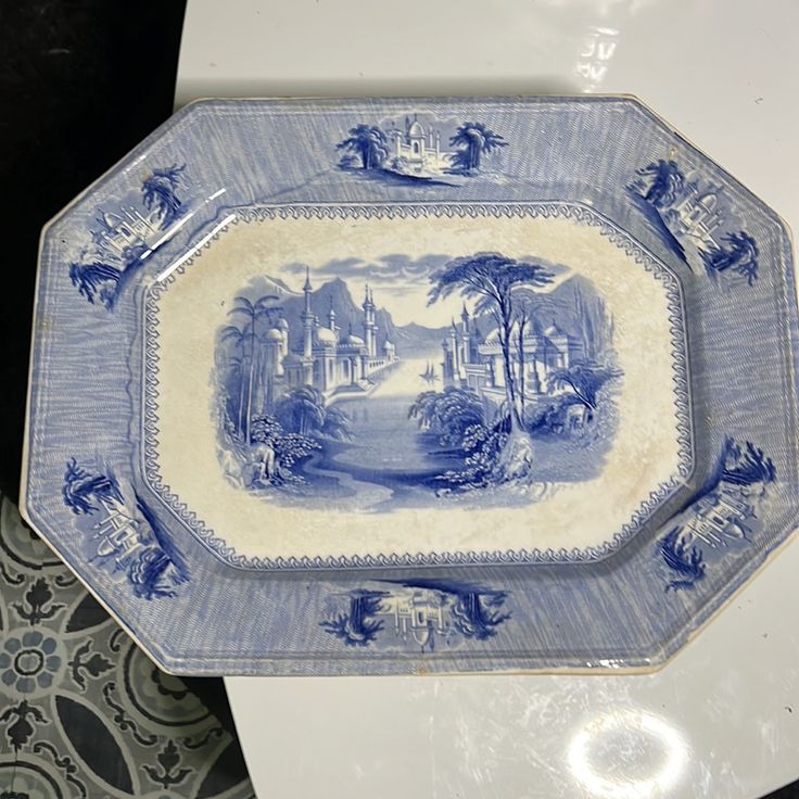 a blue and white plate sitting on top of a toilet