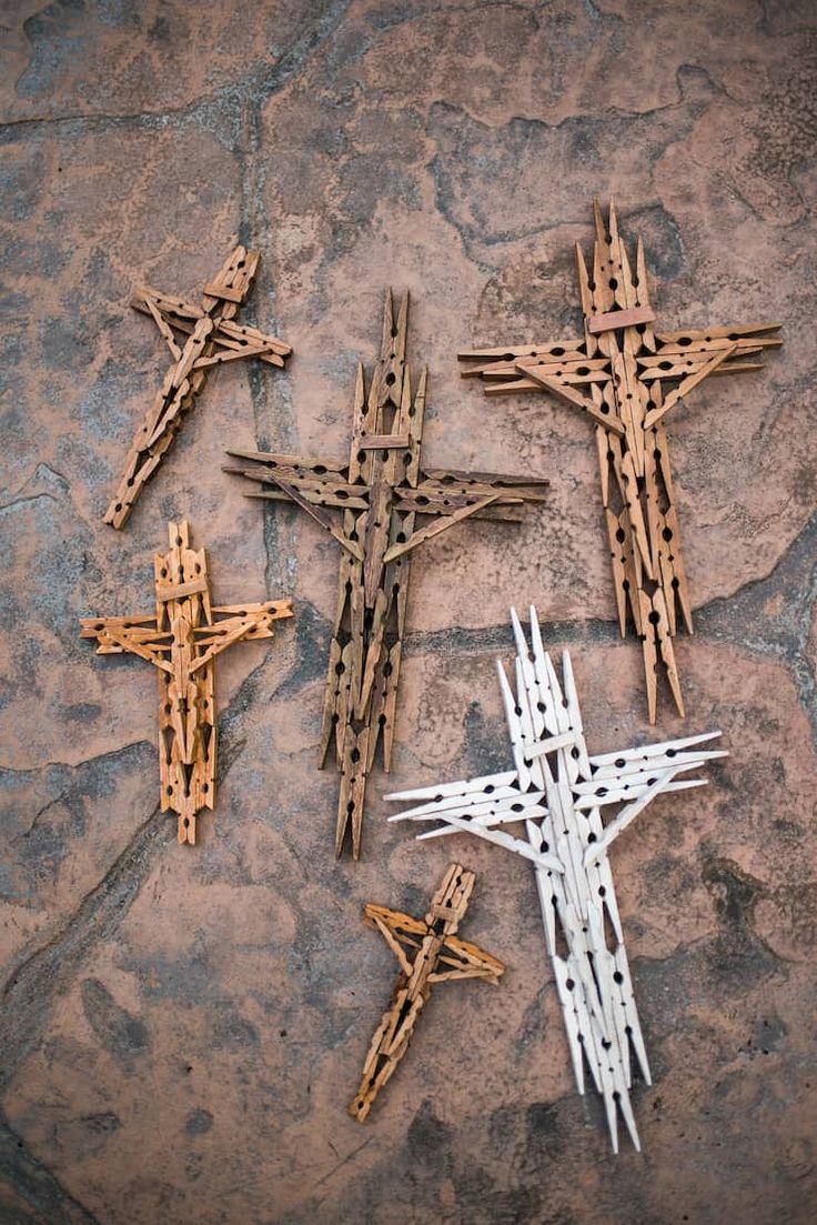 three wooden crosses sitting on top of a stone floor next to each other with nails sticking out of them