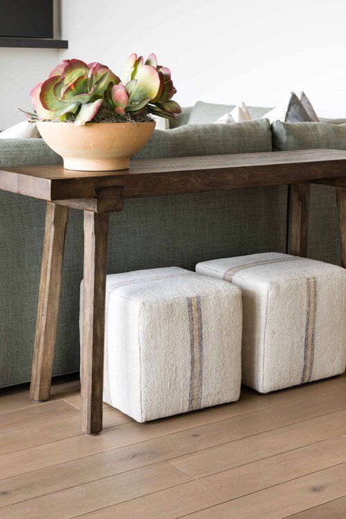 a wooden table with two stools underneath it and a potted plant on top