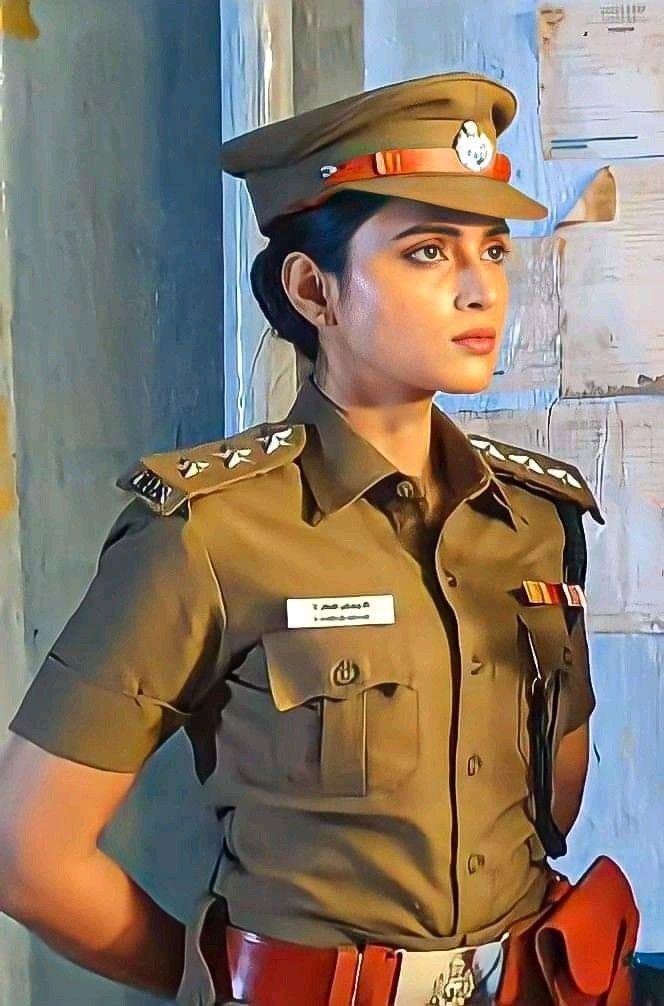 a woman in uniform is standing with her hands on her hips and looking off to the side