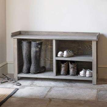 a wooden shelf with two pairs of boots on top and one pair of shoes below