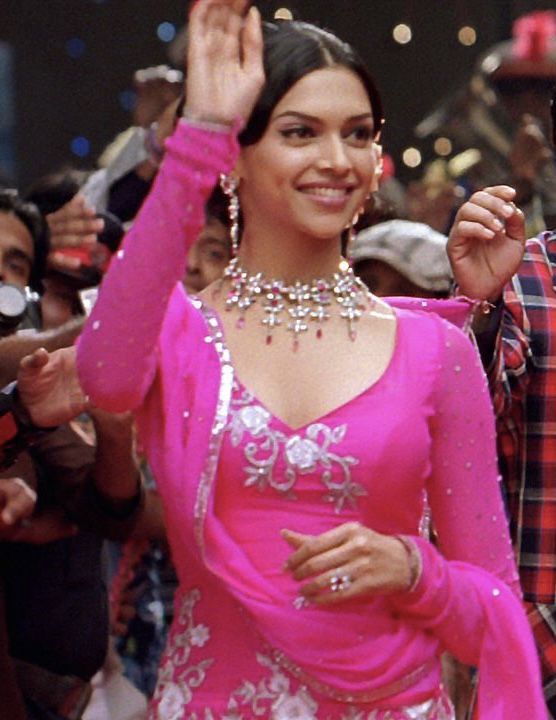 a woman in a pink dress standing next to a man