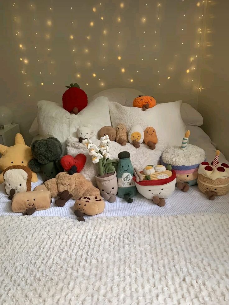 stuffed animals and other items on a bed with lights in the backround behind them