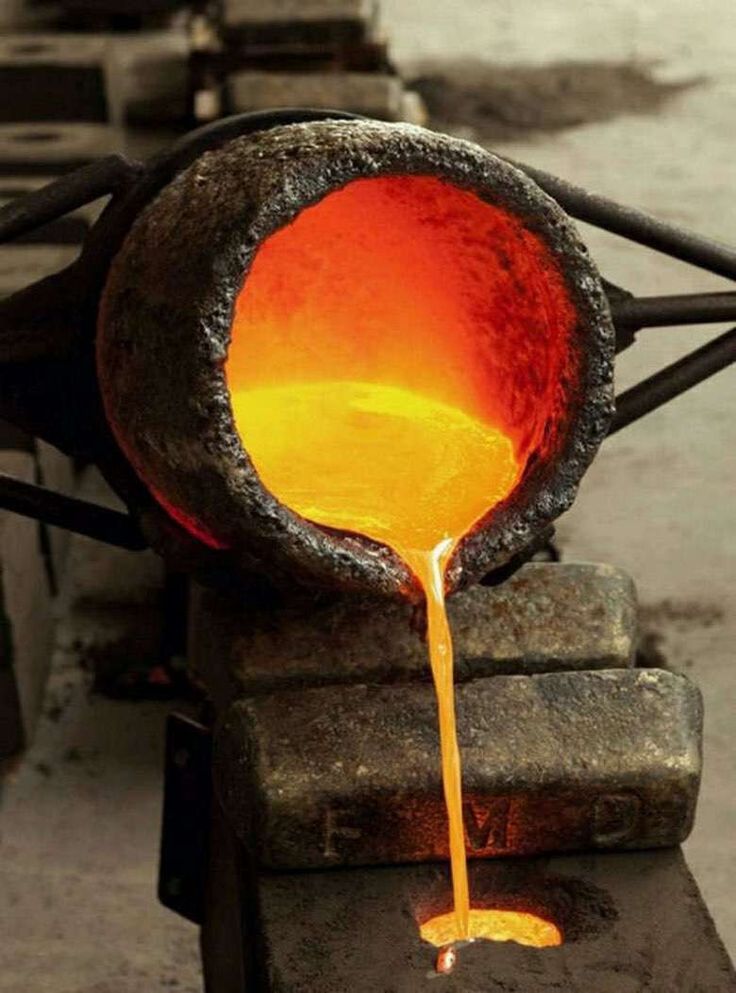 an orange liquid pouring out of a metal pot