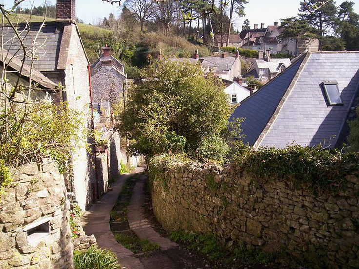 an alley way with stone buildings and trees