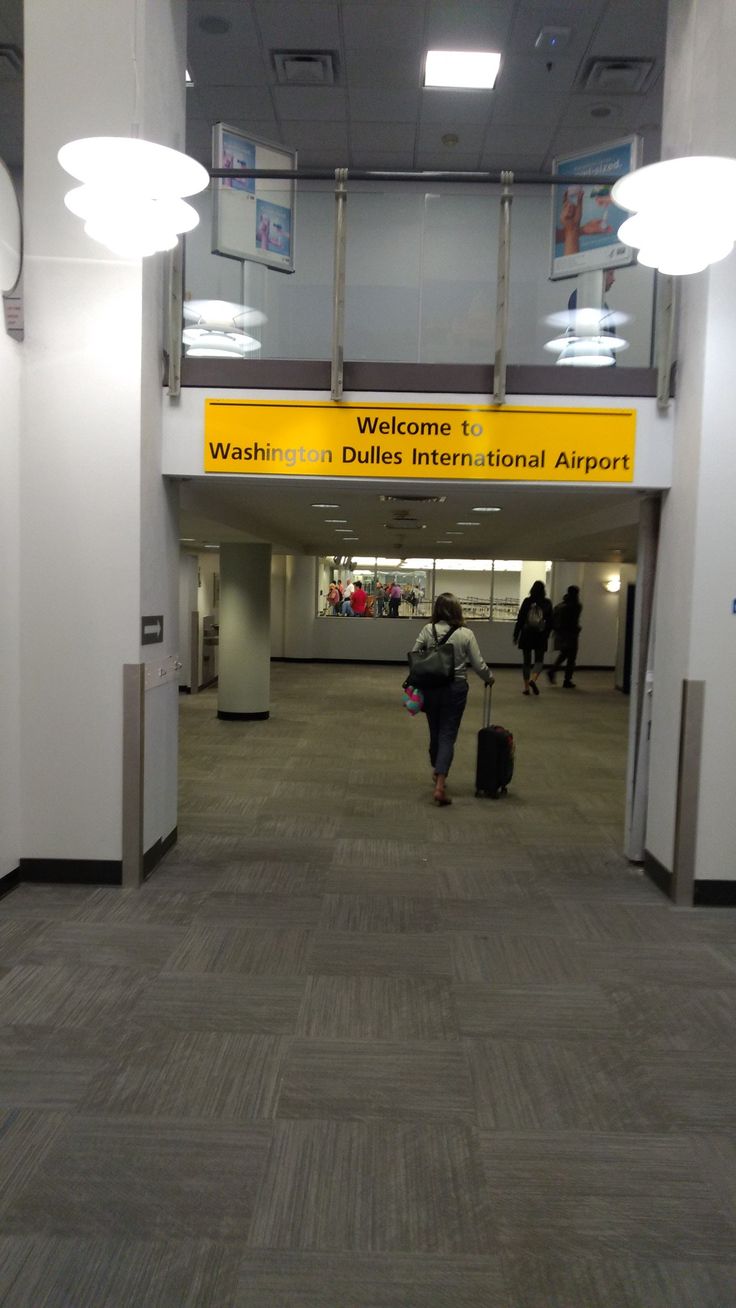 people walking through an airport with their luggage