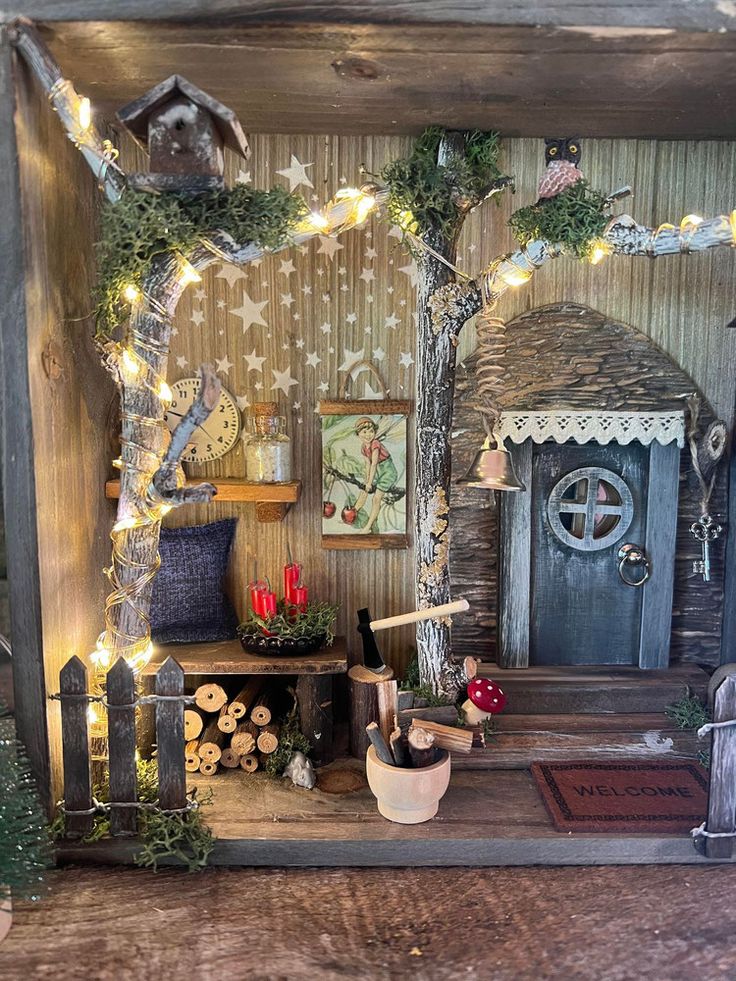 a doll house with fairy lights and decorations on the front door, sitting on a wooden table