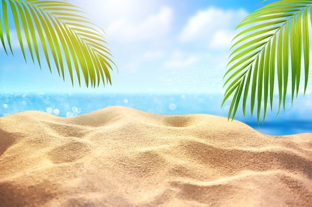 there are two palm trees in the sand at the beach with blue sky and water behind them