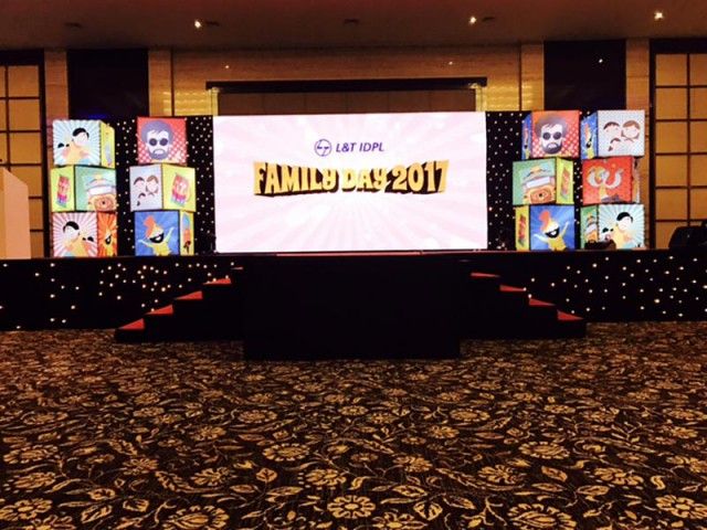 a large screen in the middle of a room with black and gold carpeted flooring