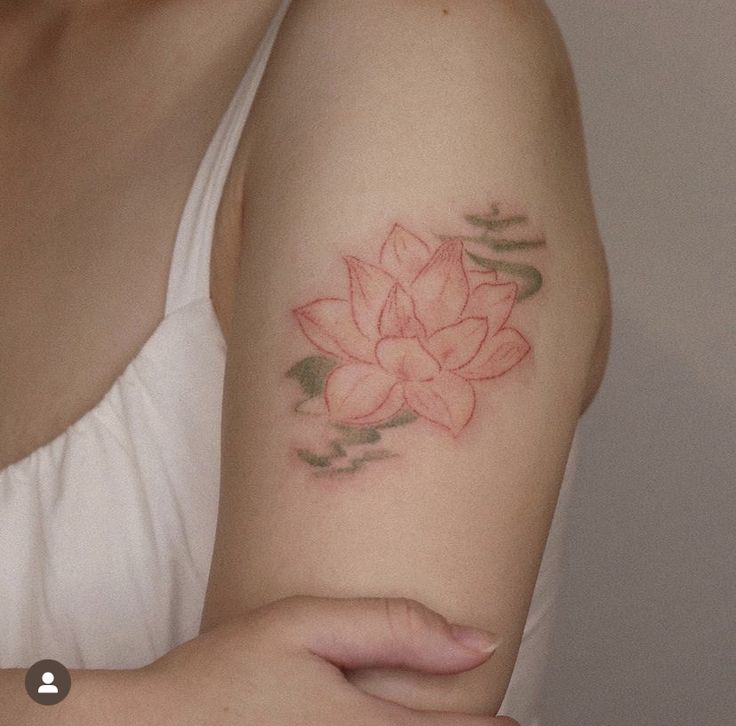 a woman's arm with a tattoo on it that has a pink flower in the center