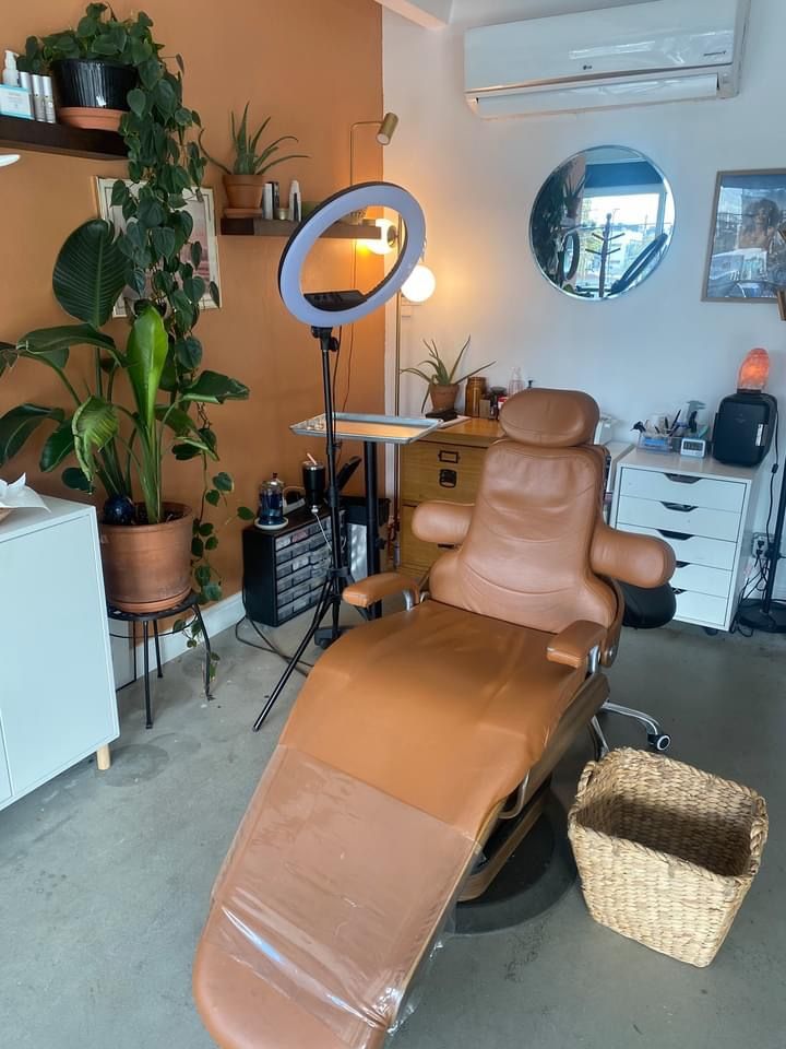 a tan reclining chair sitting in front of a mirror next to a potted plant