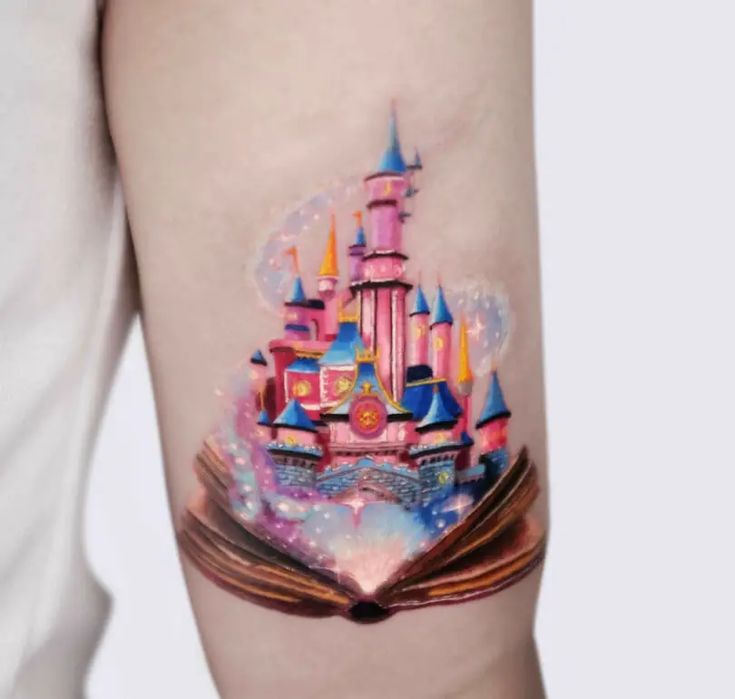 a person with a tattoo on their arm that has a book and castle on it