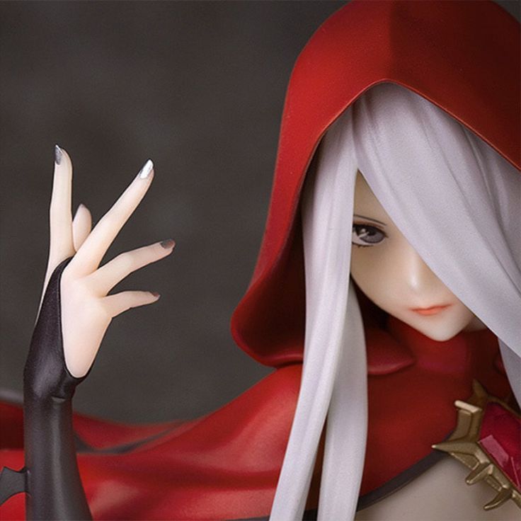 a close up of a figurine wearing a red cape and holding her hand out