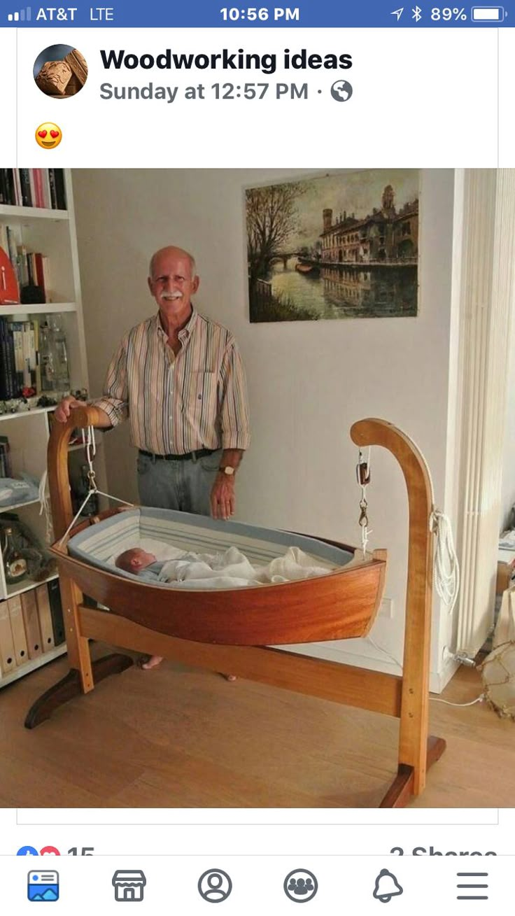 an older man standing next to a baby in a boat shaped crib with wheels