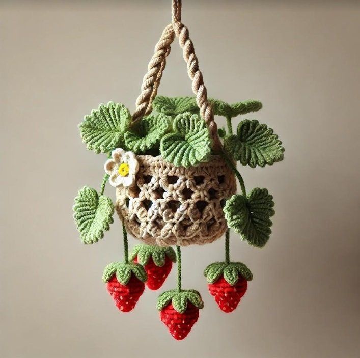 a crocheted hanging basket with strawberries and leaves