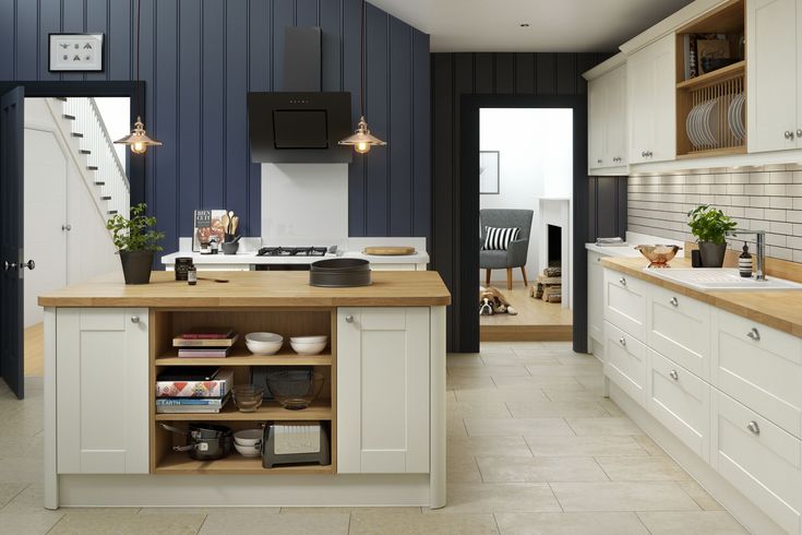 a kitchen with white cabinets and wooden counter tops next to a stairway leading up to the second floor