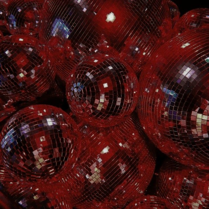 many shiny red disco balls are stacked together