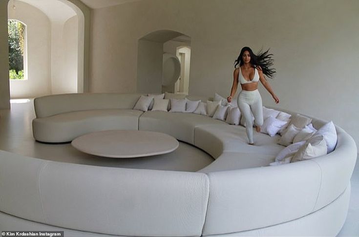 a woman standing on top of a white couch