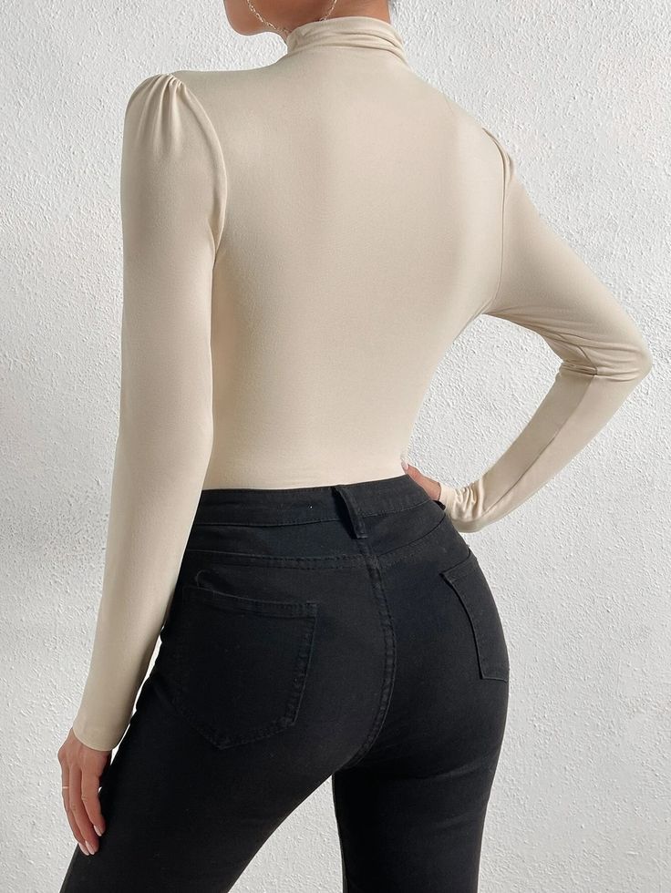 Introducing our stylish and chic Mock Neck Ruched Bodysuit - a must-have for any fashion-conscious woman who wants to make a statement. This elegant bodysuit is made of high-quality knitted fabric that offers superior comfort and flexibility. The slim-fit design features a stand collar and long sleeves that add a touch of sophistication to your wardrobe. The mock neck design highlights your neck and adds a refined touch to your outfit. Features: Color: Apricot Style: Elegant Pattern Type: Plain Type: Tee Neckline: Stand Collar Details: Wrap Sleeve Length: Long Sleeve Sleeve Type: Regular Sleeve Waist Line: Natural Fit Type: Slim Fit Fabric: High Stretch Material: Knitted Fabric Composition: 95% Polyester, 5% Elastane Care Instructions: Machine wash or professional dry clean Sheer: No Featu Ruched Bodysuit, Wrap Sleeve, Elegant Bodysuit, Collar Details, Comfy Jumpsuits, Elegant Pattern, Style Elegant, Shoulder Sleeve, Neck Designs