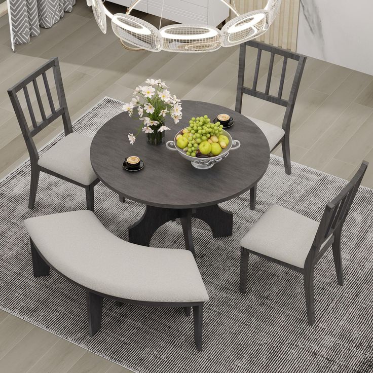 a dining room table with four chairs and a bowl of fruit on top of it