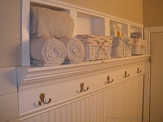 towels are lined up on the shelf in this bathroom