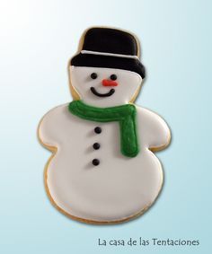 a cookie shaped like a snowman with a green scarf and hat on it's head